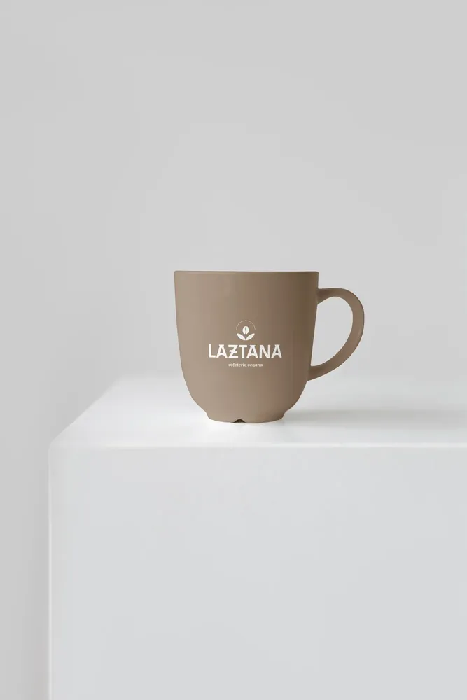 Taza beige con el logo de la cafetería vegana Laztana en Bilbao.