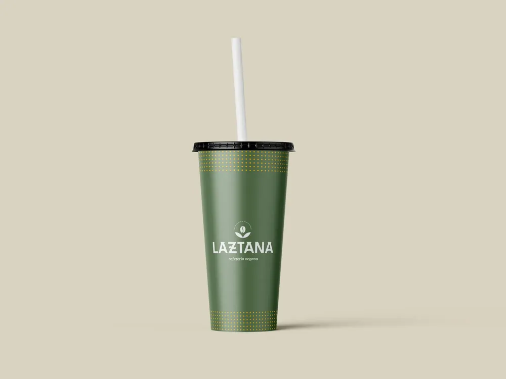 Vaso metálico con una pajita blanca y el logo de la cafetería vegana Laztana en Bilbao.